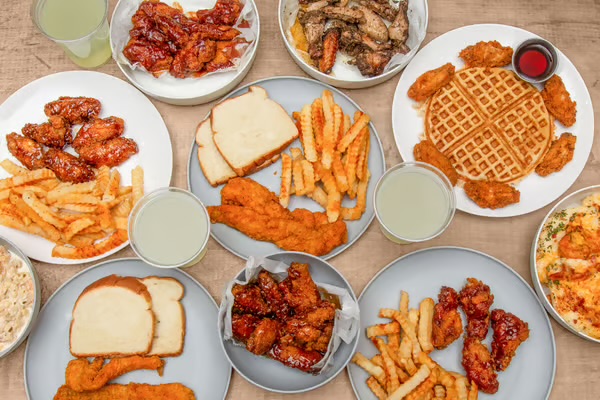 Signature soul food spread with fried chicken wings, fried fish, mac and cheese and collards at Top Tier Eatery Winston-Salem NC